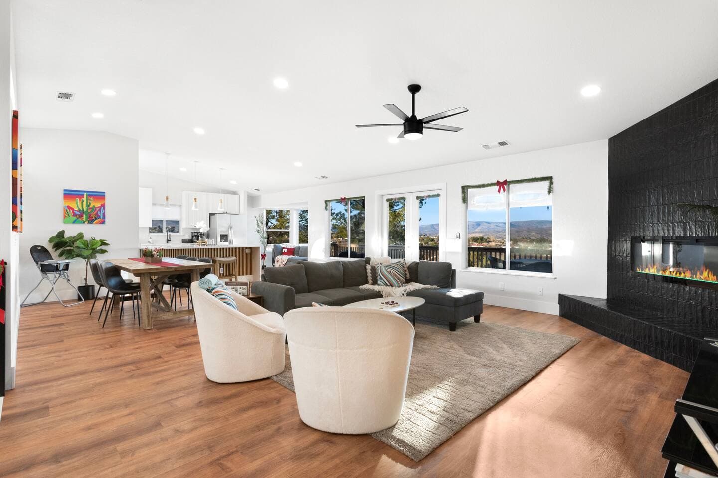 Unwind in this bright and open living space, featuring panoramic views, cozy seating, a modern fireplace, and a fully equipped kitchen perfect for entertaining.
