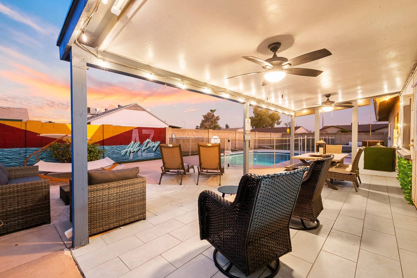 Paradise Found: Where every moment is a splash of relaxation. Our vacation rental's backyard oasis offers the perfect blend of serenity and fun, featuring a crystal-clear pool, a charming dining area, vibrant wall mural, and a cozy daybed for endless